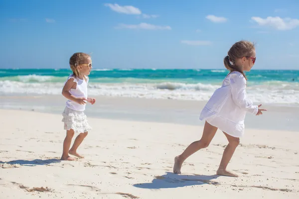 Two little sisters in white clothes have fun at tropical sand beach — Stock Photo, Image