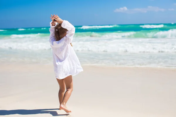 Imádnivaló kicsi lány táncol egy egzotikus fehér strandon napsütéses napon — Stock Fotó