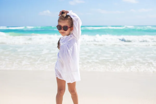 Beautiful little girl having fun on an exotic white beach at sunny day — Stock Photo, Image