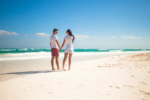 Back view of young couple in love walking at tropical white beach — Stock Photo, Image