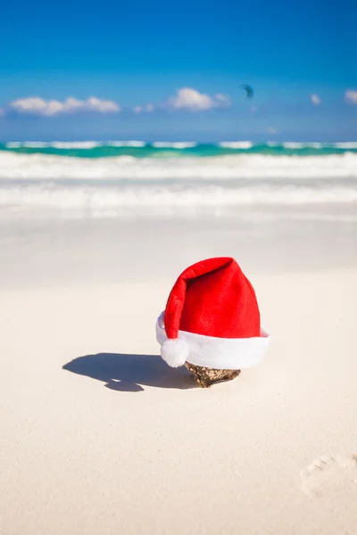 Santa claus kapelusz na białe piaszczyste wybrzeże — Zdjęcie stockowe