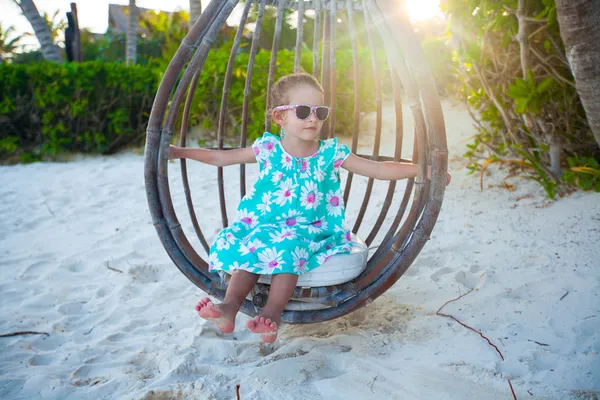 Glad liten tjej njuta av swing på karibiska stranden — Stockfoto