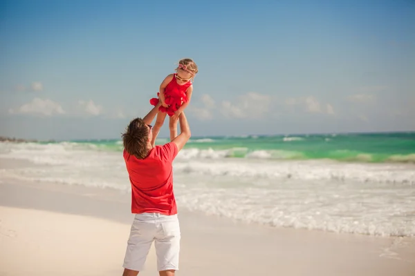 Jovem pai feliz e pequena filha se divertindo na praia branca em dia ensolarado — Fotografia de Stock
