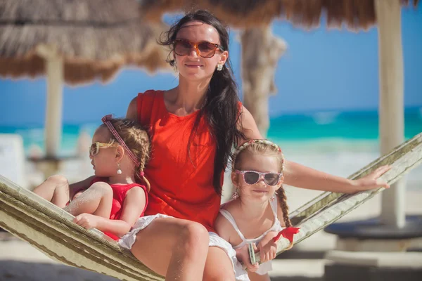 Joven madre y sus pequeñas hijas descansando en una hamaca en la playa blanca del Caribe —  Fotos de Stock