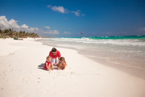 Padre e le sue adorabili bambine che giocano sulla spiaggia — Foto Stock