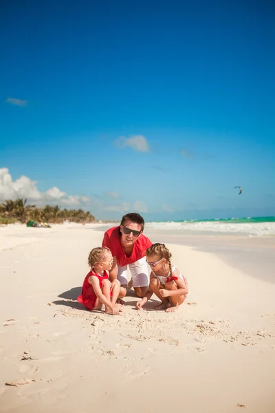 Father and his adorable little daughters playing on the beach — Stock Photo, Image