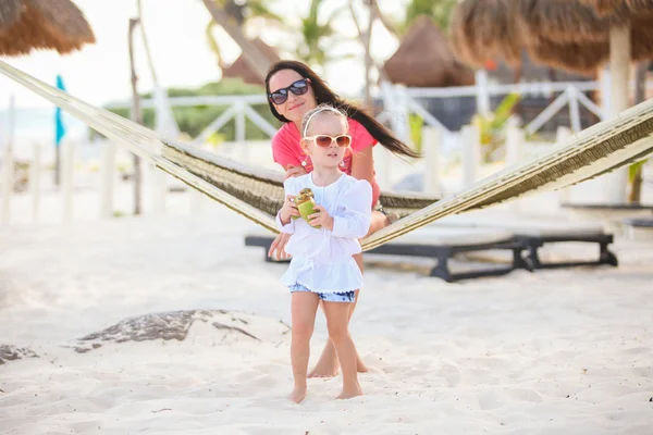 Mother with her baby daughter in hammock on a perfect white sand beach — Stock Photo, Image