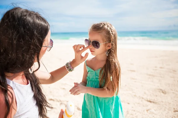 Mère appliquant de la crème solaire sur le nez de son enfant — Photo