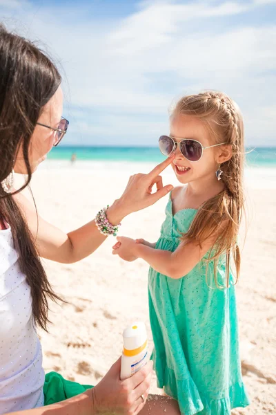 Mutter cremt ihr kleines Kind mit Sonnencreme ein — Stockfoto