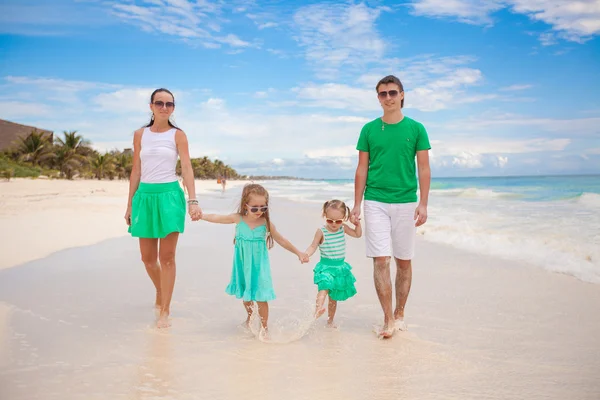 Young beautiful family of four enjoyed relaxing on the beach — Stock Photo, Image