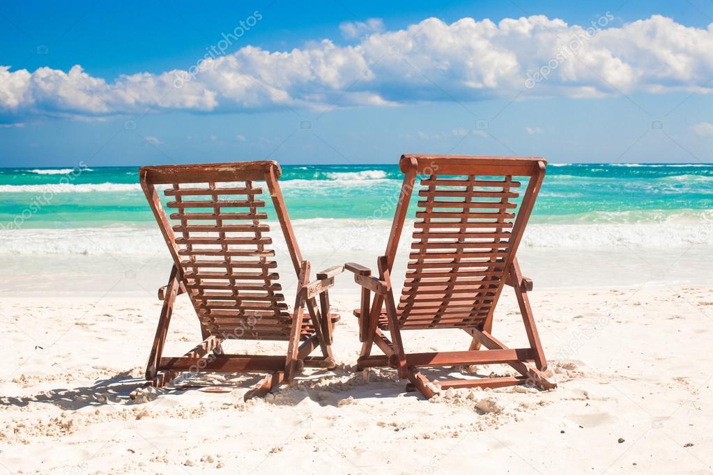 Beach wooden chairs for vacations and relax on tropical white sand beach in Tulum, Mexico