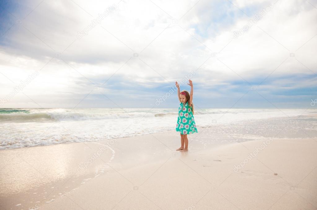 Little cute girl running on the white sandy beach in Mexico