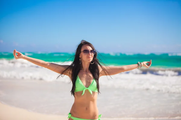 Young woman enjoying the holiday spread her hands on a white, tropical beach — Stock Photo, Image