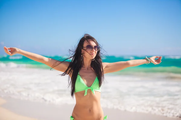 Junge schöne Frau genießt den Urlaub und breitet ihre Hände an einem weißen, tropischen Strand aus — Stockfoto