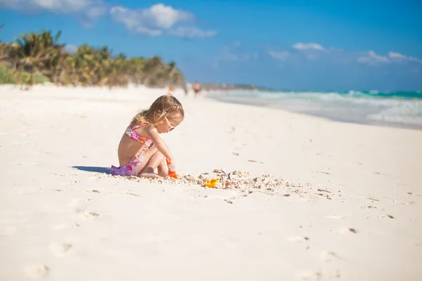 Adorable niña en traje de baño jugando en la playa tropical de carroña —  Fotos de Stock