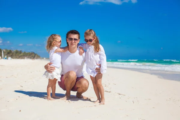 Joven padre feliz y pequeñas hijas divirtiéndose en la playa blanca en el día soleado — Foto de Stock