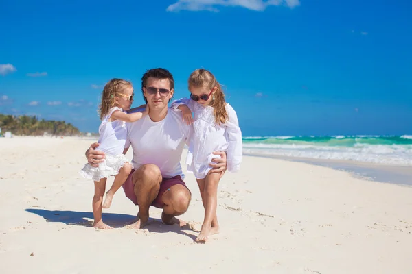 Joven padre feliz y pequeñas hijas divirtiéndose en la playa blanca en el día soleado —  Fotos de Stock