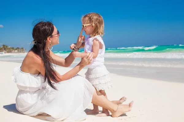 Adorable little girl having fun with her young mother on the white sandy beach in Tulum, Mexico — Stock Photo, Image