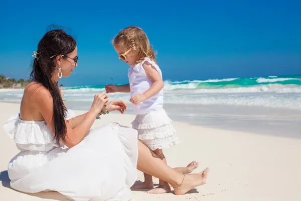 Adorable little girl having fun with her mother on the white sandy beach — Stock Photo, Image