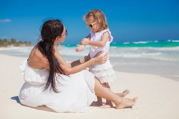 Adorable little girl having fun with her mother on the white sand — Stock Photo, Image