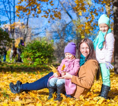genç anne ve onun sevimli kız sıcak güneşli sonbahar Park