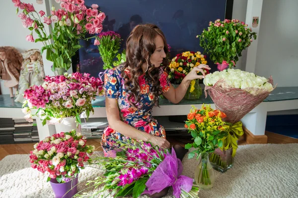 Unga vackra kvinnan i blommor av rummet — Stockfoto