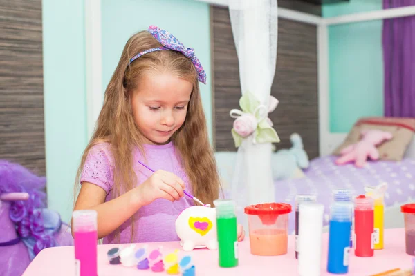 Adorable Little girl draws paints at her table in the room — Stock Photo, Image