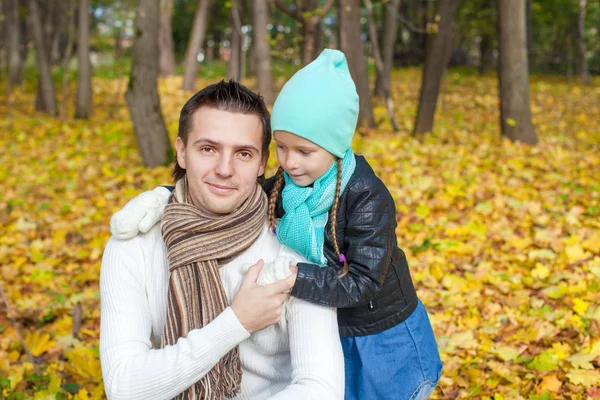 Портрет молодого отца, гуляющего со своей милой дочерью в осеннем парке — стоковое фото