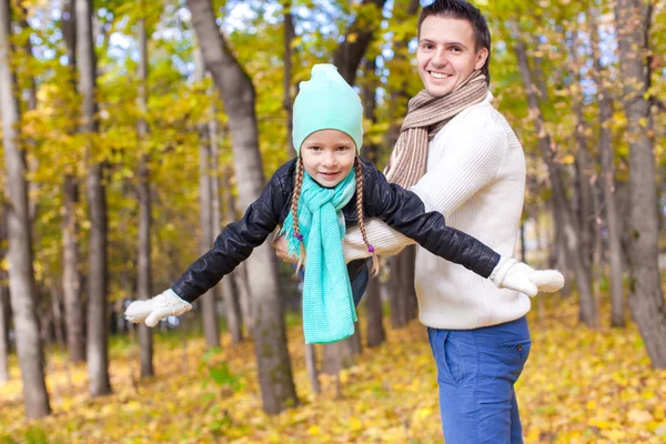 Boldog apa és a szórakozás, a parkban a napsütéses őszi napon kis lánya — Stock Fotó