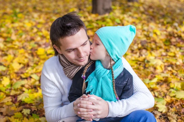 Lilla flickan kysser lycklig far i höst park utomhus — Stockfoto