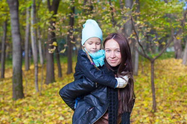 Gelukkig moeder en haar schattige dochter plezier in gele herfst bos op een warme zonnige dag — Stockfoto