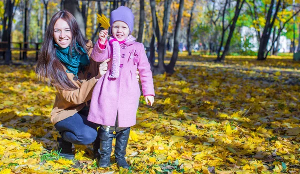 Little girl with young mother in yellow autumn park on a warm sunny day — Stock Photo, Image