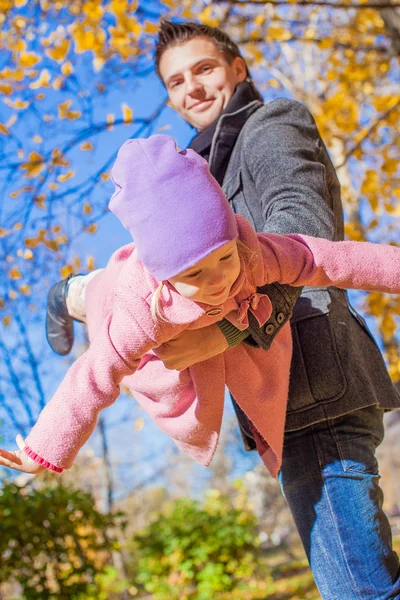 Sevimli küçük kız eğleniyor sonbahar park güneşli bir günde mutlu baba ile — Stok fotoğraf