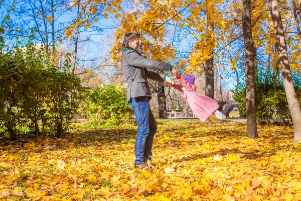 Liten flicka med glada far ha kul i höst park på en solig dag — Stockfoto