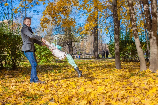 Sevimli küçük kız ile eğleniyor sonbahar park güneşli bir günde mutlu baba — Stok fotoğraf