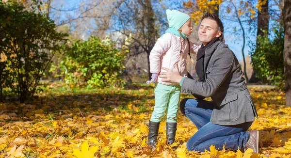 Little girl kissing her father in autumn park — Stock Photo, Image