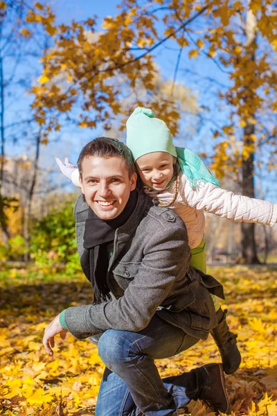 Sevimli küçük kız eğleniyor sonbahar park güneşli bir günde mutlu baba ile — Stok fotoğraf