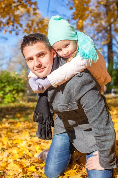 Adorable little girl with happy father having fun in autumn park on a sunny day — Stock Photo, Image