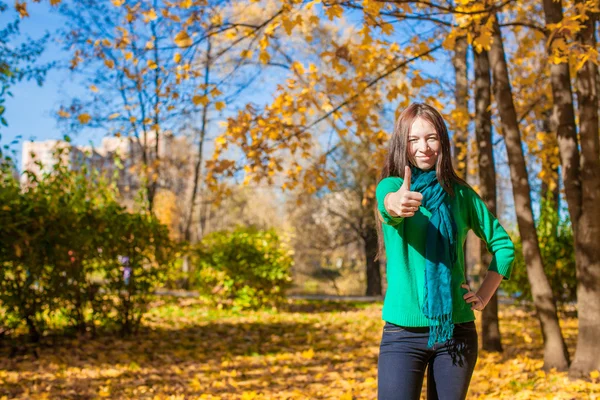 Mujer joven en el parque amarillo de otoño mostrando un pulgar hacia arriba —  Fotos de Stock
