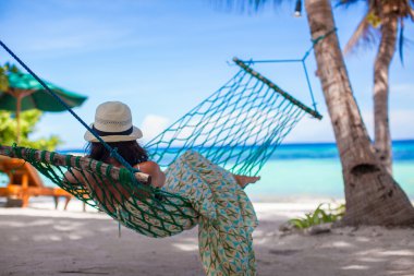 çok güzel genç bir kadın tropik sahilde hamakta yatan