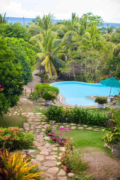 Fin utsikt over hagen og svømmebassenget på et koselig lite hotell. – stockfoto