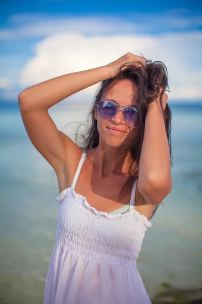 Beautiful young girl standing at beach and looking in camera — Stock Photo, Image