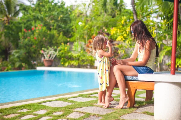 Young mother and her little daughter have fun near the swimming pool — Stock Photo, Image