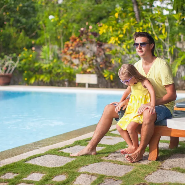 小女孩和她的父亲在异国风情度假村的游泳池附近有乐趣 — 图库照片