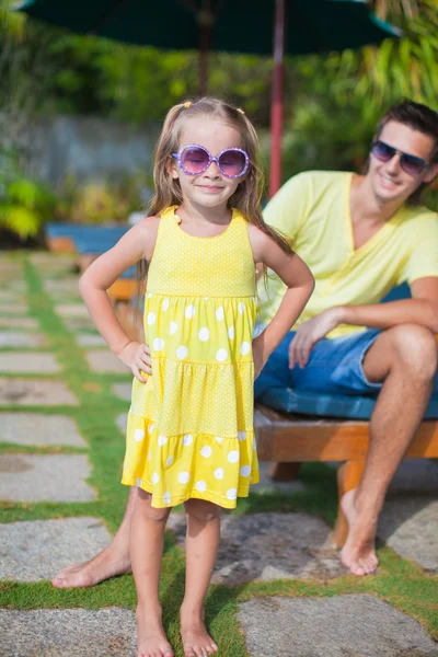 Closeup cute daughter background her young dad at the swimming pool — Stock Photo, Image