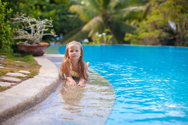 Piccola ragazza adorabile in piscina guarda la fotocamera — Foto Stock