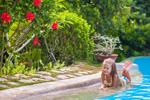 Little adorable girl in the swimming pool looks at camera — Stock Photo, Image