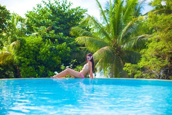 Hermosa mujer joven disfrutando de la piscina tranquila de lujo — Foto de Stock