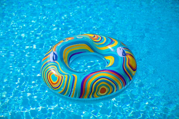 Colorido flotador de la piscina en el lavabo azul — Foto de Stock