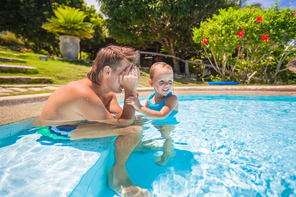 Pouco bonito menina jogar com o pai na piscina em hotel tropical — Fotografia de Stock